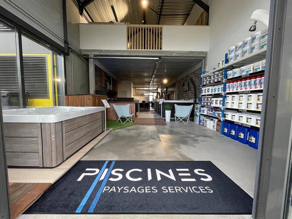 entrée de magasin piscines paysages services avec tapis noir et lumiere a guerante avec produits chimiques et spa