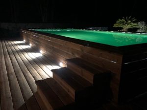piscine en bois hors sol éclairée de nuit en vert