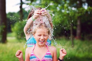 Enfants en maillot de bain jouant avec une bombe à eau