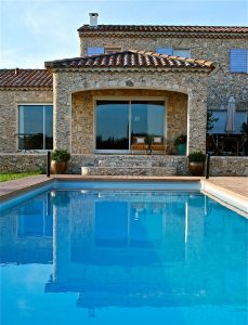 Piscine extérieure dans le jardin d'une maison en pierres