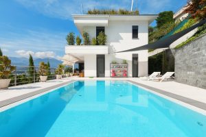 Maison à étage avec piscine extérieure bleu turquoise vue sur la montagne