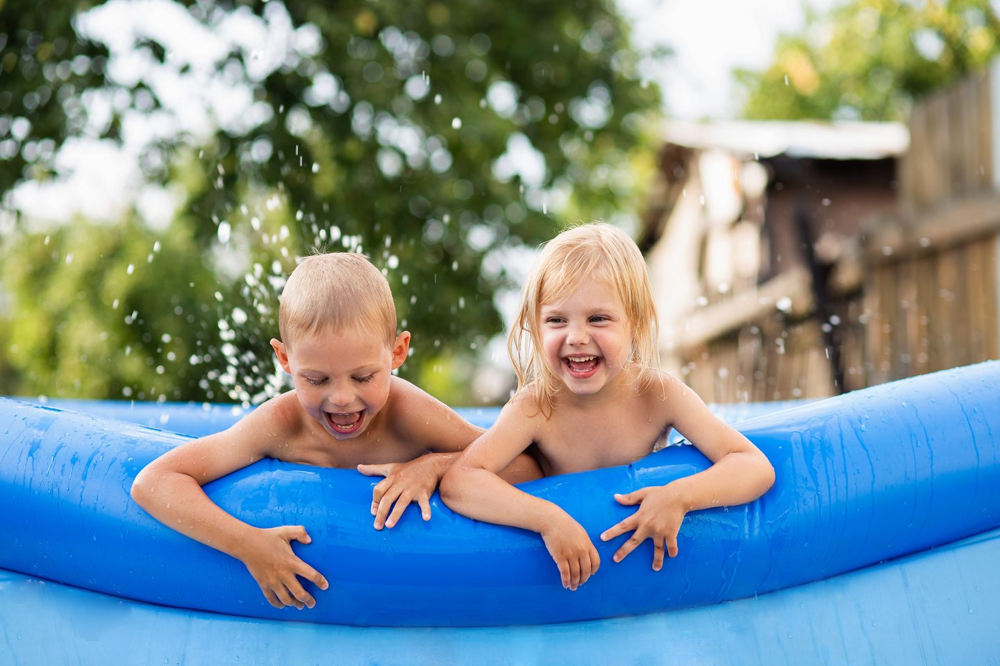 Enfants dans une piscine hors-sol gonflable bleue