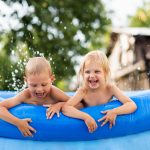 Enfants dans une piscine hors-sol gonflable bleue