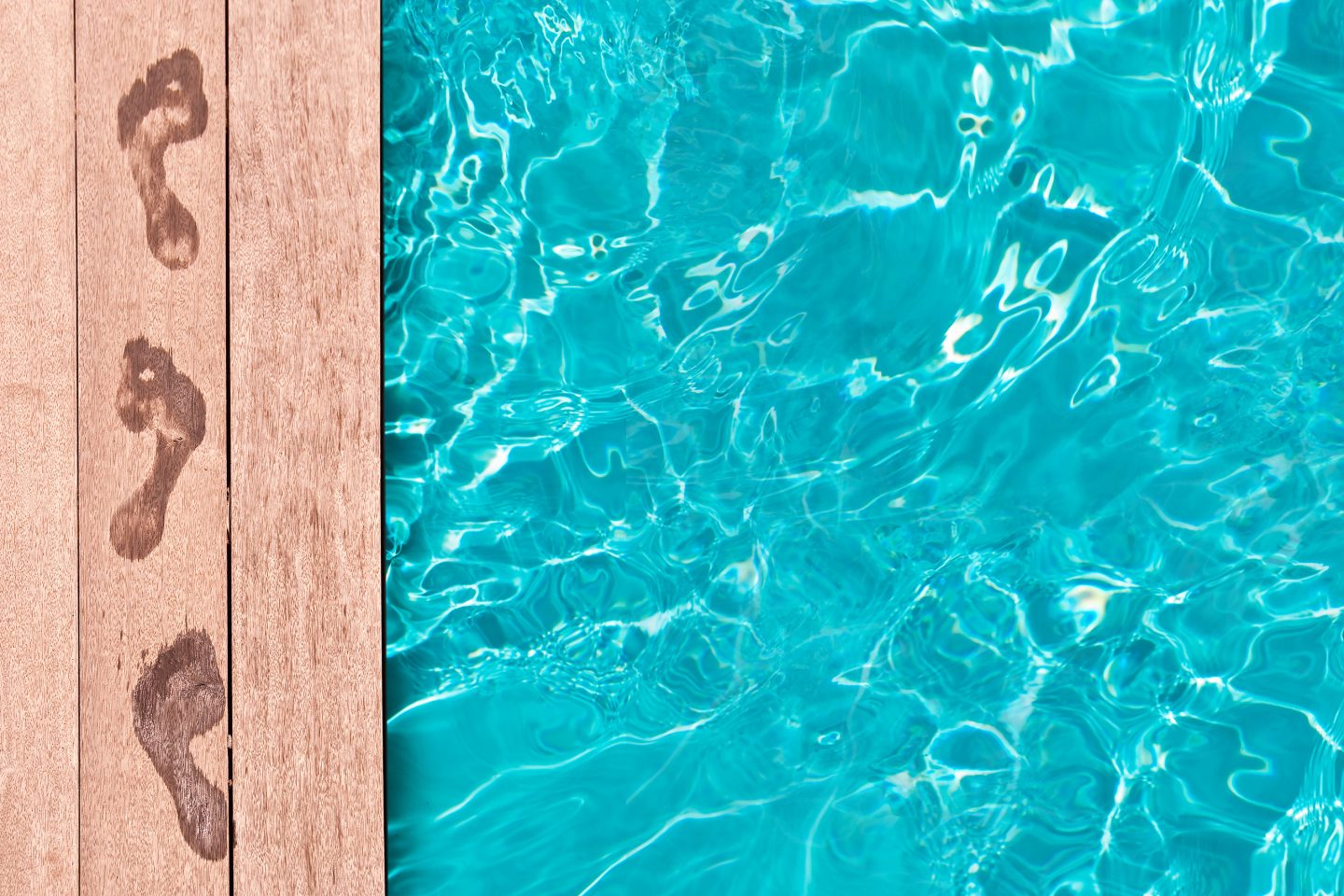 Piscine enterrée avec terrasse en bois et traces de pas