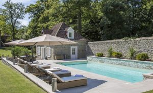 Piscine enterrée avec transats et parasol