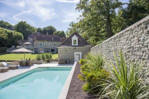 Piscine extérieure enterrée avec jardin verdoyant et terrasse aménagée