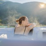 femme se relaxant dans un jacuzzi au bord de la montagne