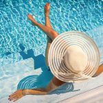 Femme dans une piscine avec chapeau de paille se relaxant