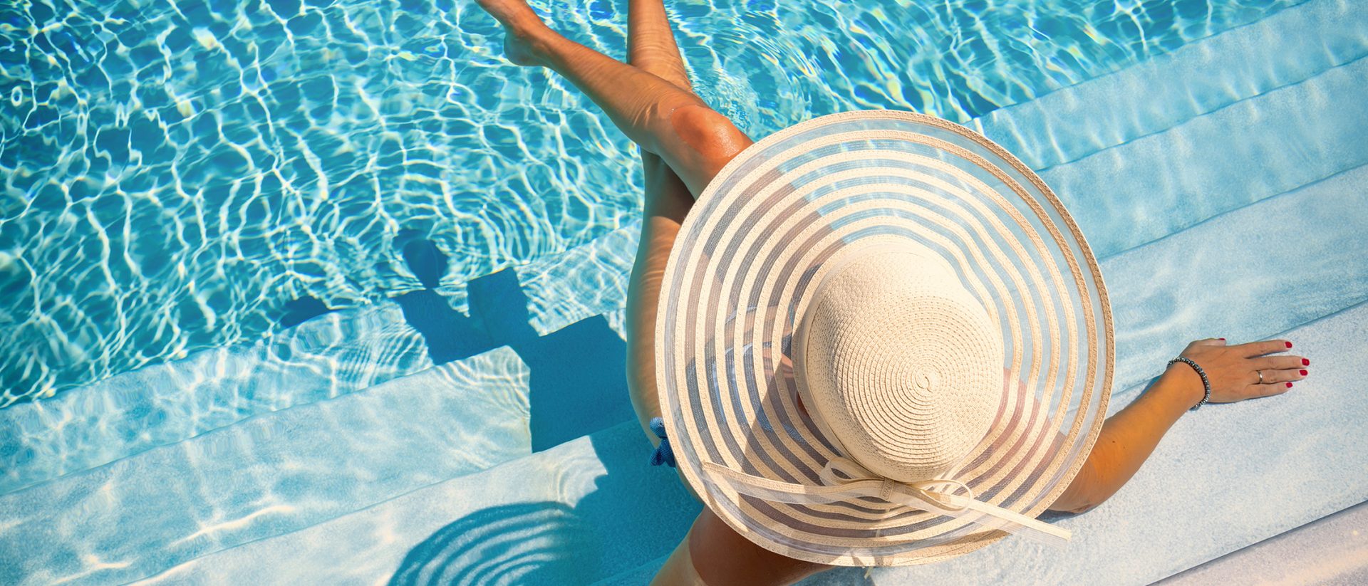 Femme dans une piscine avec chapeau de paille se relaxant