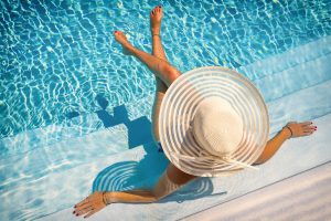 Femme dans une piscine avec chapeau de paille se relaxant
