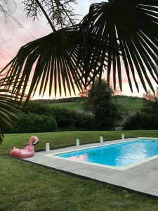 piscine enterree avec bouee rose et couché de soleil