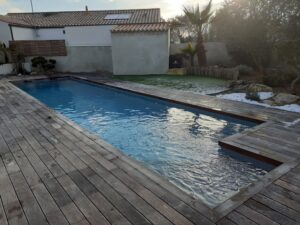 piscine enterree dans un jardin avec terrasse en bois